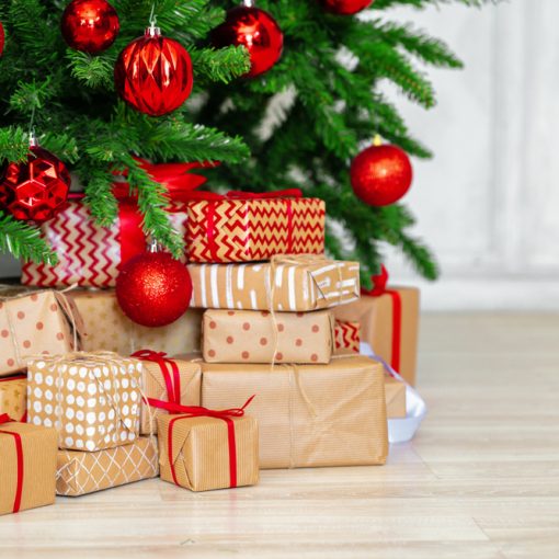 This picture shows a stack of wrapped presents under a Christmas tree