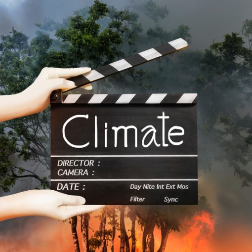 This is a picture that shows hands holding movie slate in fire backdrop