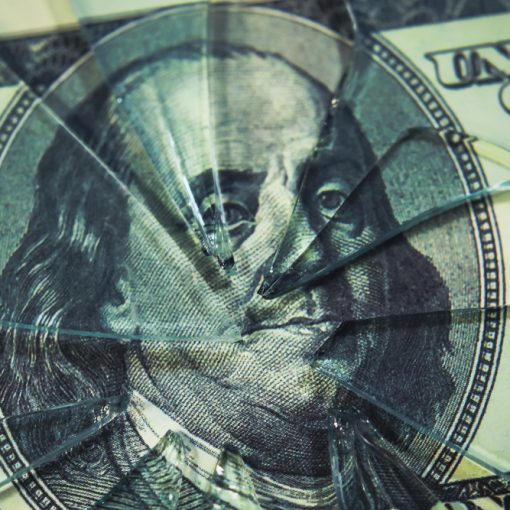 The image shows cracks on a broken glass atop a dollar