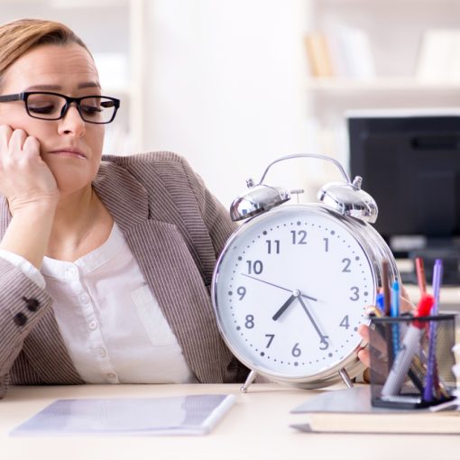 This is the image of a dull businesswoman watching the clock