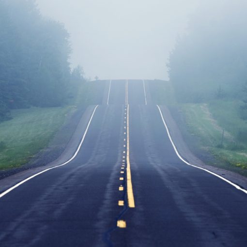 Image shows a foggy, difficult road ahead