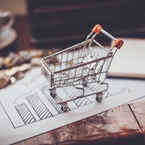 An image of shopping cart around money