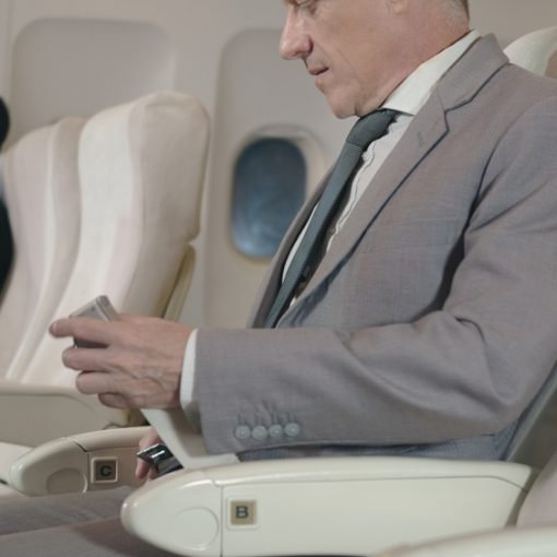 The image shows Businessman fastening seatbelt on Airplane