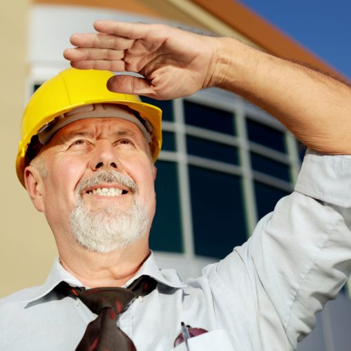 The image shows an old engineer looking towards the future