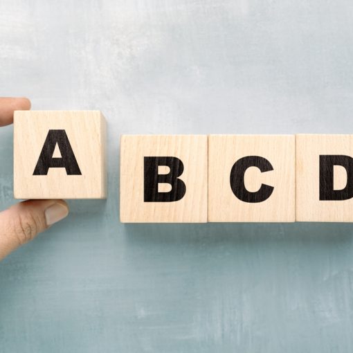 The image shows some wooden cubes with alphabets