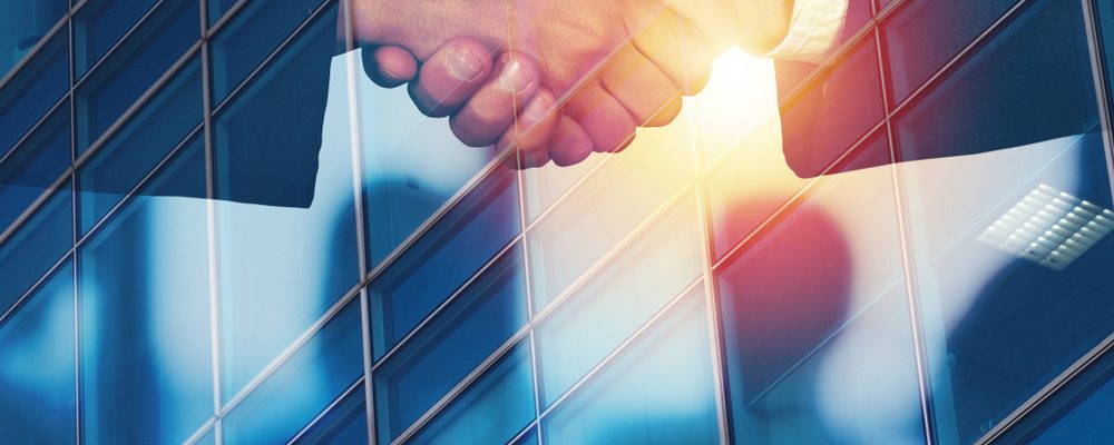 The image shows business partners doing a handshake