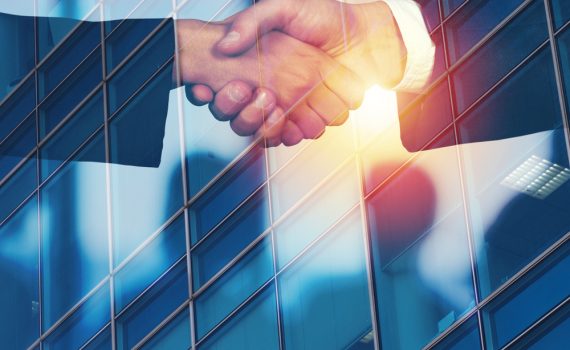 The image shows business partners doing a handshake