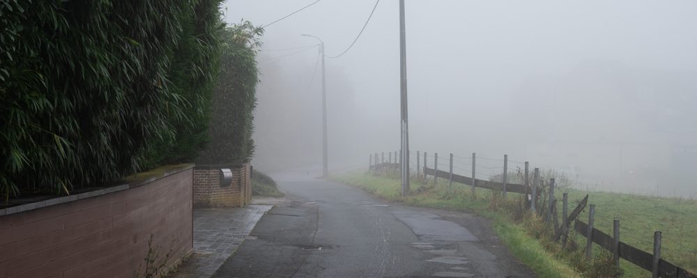 The picture shows a foggy road looking dirty with potholes