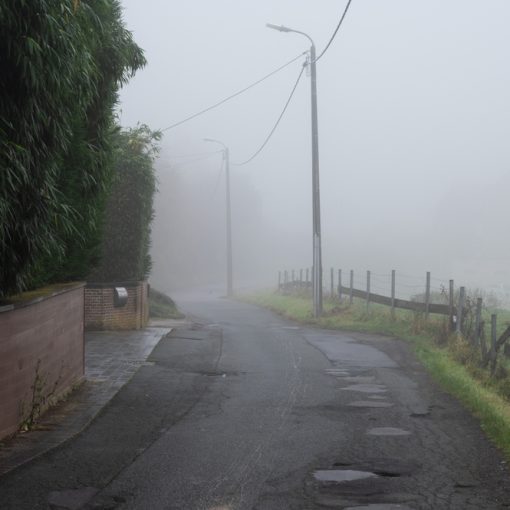 The picture shows a foggy road looking dirty with potholes