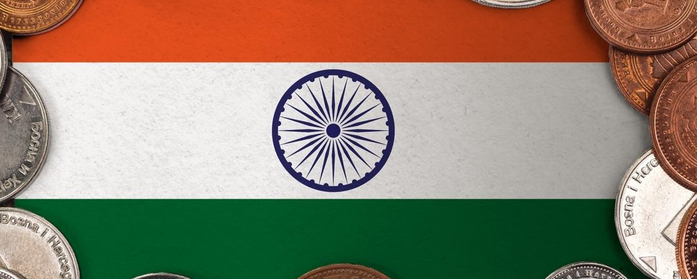 The image shows coins on a flag of India