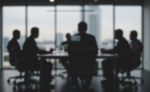 The image shows a worried group of businesspeople in discussion
