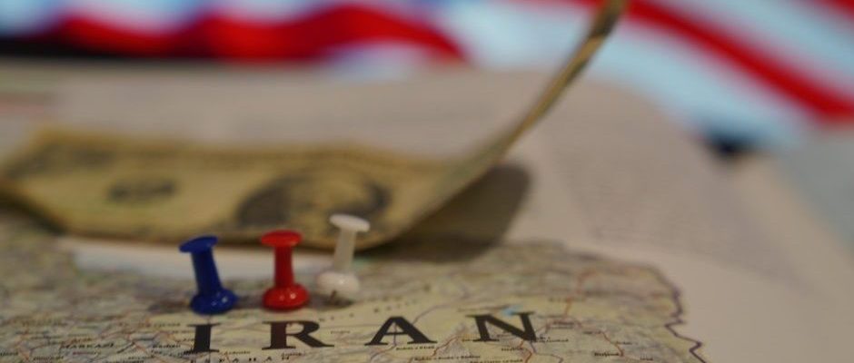The image shows Iran highlighted against US flag and dollars