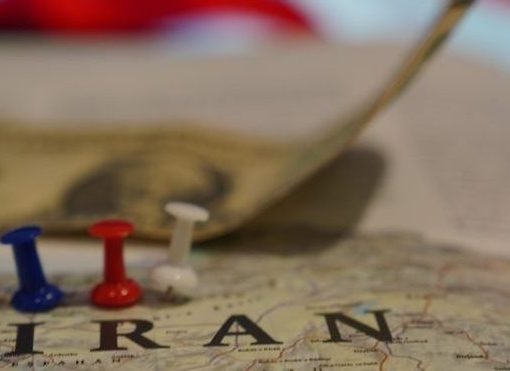 The image shows Iran highlighted against US flag and dollars