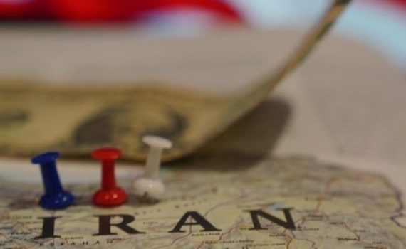The image shows Iran highlighted against US flag and dollars