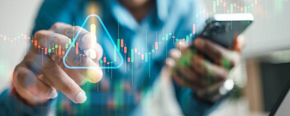 The image shows an investor holding smartphone, with caution towards stock market