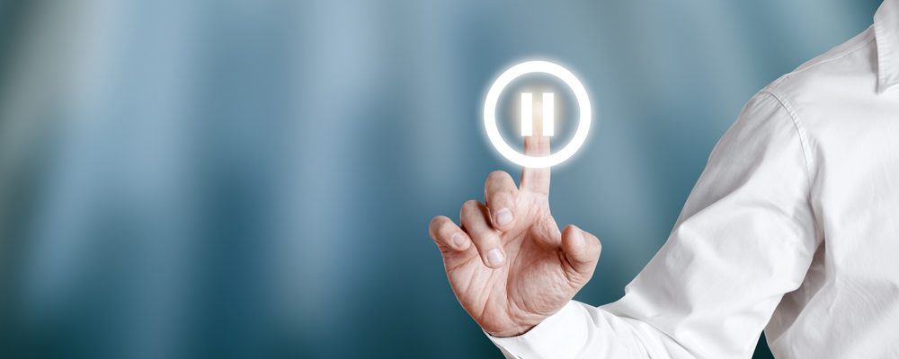 Pause Button being pressed by Businessman on Virtual Screen