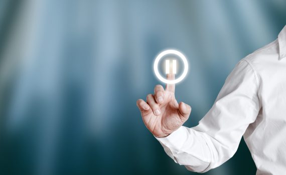 Pause Button being pressed by Businessman on Virtual Screen