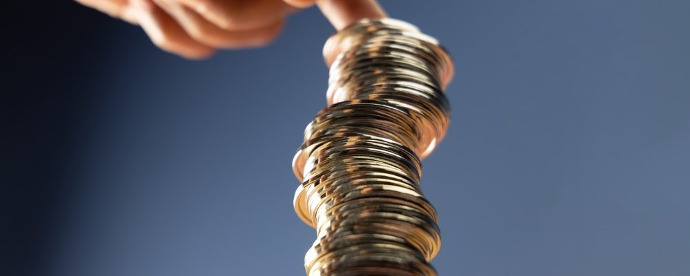 Hands Supporting Unstable Coin Stack